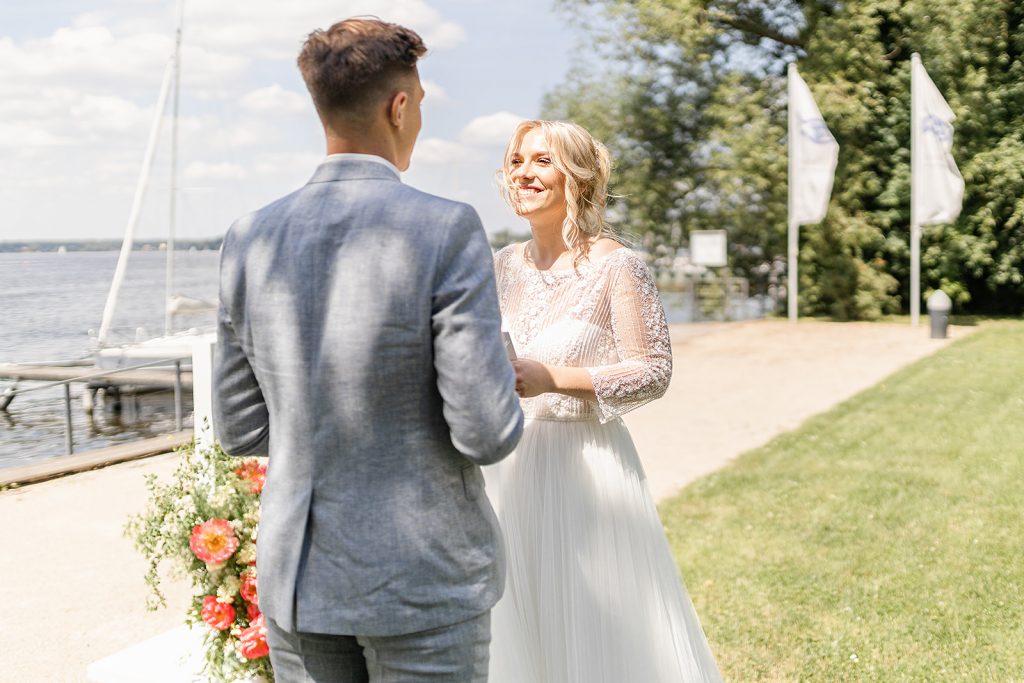 Eheversprechen am See, Brautpaar, Braut, Bräutigam, Hochzeitskleid weiß, Anzug grau
